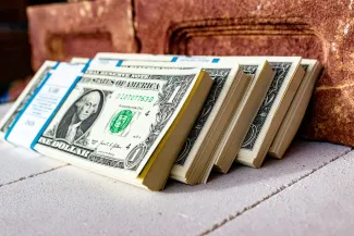 a stack of money sitting on top of a table by Marek Studzinski courtesy of Unsplash.