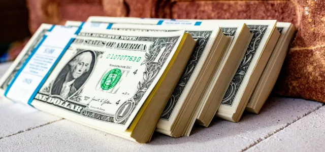 a stack of money sitting on top of a table by Marek Studzinski courtesy of Unsplash.