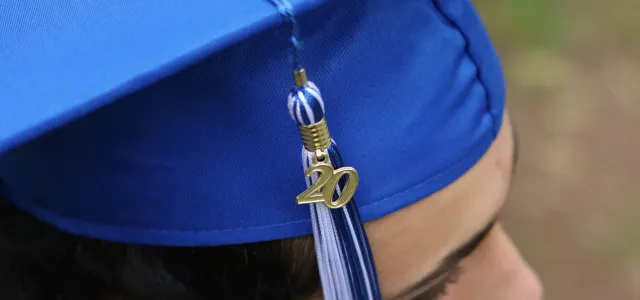 person wearing blue academic hat by Foto Phanatic courtesy of Unsplash.